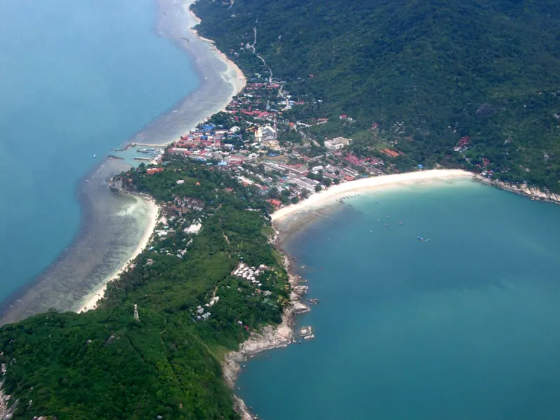 Vista aérea de la península de Haad Rin: el pueblo entre dos bahías y, a la derecha, la playa curva donde se hace la fiesta.